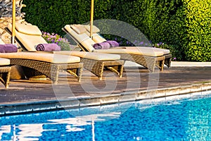 Beautiful outdoor swimming pool with bed deck chair and umbrella in resort for travel and vacation