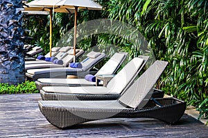 Beautiful outdoor swimming pool with bed deck chair and umbrella in resort for travel and vacation