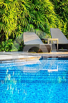 Beautiful outdoor swimming pool with bed deck chair and umbrella in resort for travel and vacation