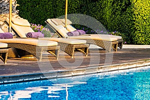 Beautiful outdoor swimming pool with bed deck chair and umbrella in resort for travel and vacation