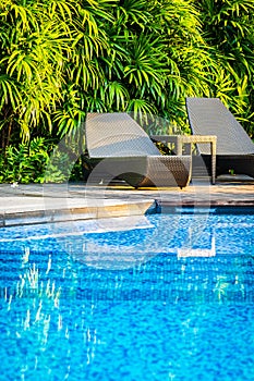 Beautiful outdoor swimming pool with bed deck chair and umbrella in resort for travel and vacation