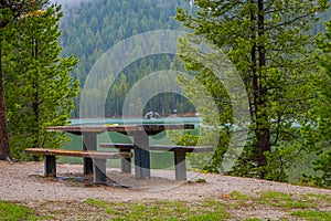 Beautiful outdoor view of metallic and wooden table a chair located in the lakeshore with a gorgeous landscape of Jenny