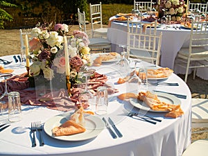 Beautiful outdoor wedding decoration in city. Candles and dried flowers and accessories with bouquets and glasses on