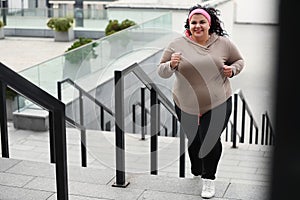 Beautiful overweight woman running up stairs