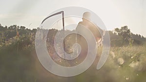 Beautiful overweight woman with a scythe braiding her hair in sunlight on the green summer field. Folklore, traditions