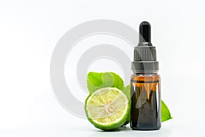 Beautiful packshot of Bergamot essential oil in a small glass bottle with fresh bergamot fruit with green leaf on white background