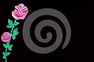 Beautiful painted pink rose on one side on a black background.