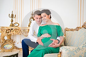 Beautiful pair of parents in anticipation of the child. Heart on pregnant tummy