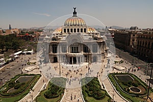 The beautiful Palacio de Bellas Artes Palace of Fine Arts and the square and flower beds in front of it on a busy day, Mexico City