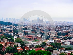 Beautiful panorama of Barcelona with the silhouette of the Basilica de la Sagrada Familia on the horizon in fog. European city