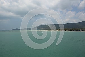 Beautiful panorama day shot of calm blue turquoise ocean water with wild islands, white sand beaches, jungle hills, light blue sky