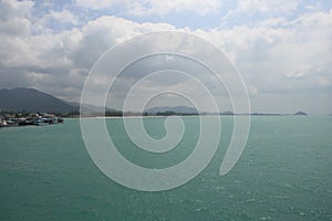 Beautiful panorama day shot of calm blue turquoise ocean water with wild islands, white sand beaches, jungle hills, light blue sky