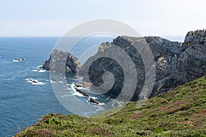 Beautiful panorama of large cliffs with green grass and Atlantic Ocean with tourquoise water photo