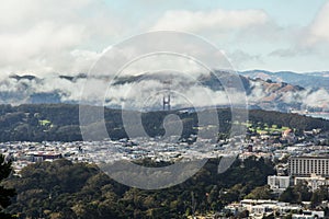 A beautiful panorama of San Francisco downtown and the famous Golden Gate Bridge in the fog as seen from the Twin Peaks,