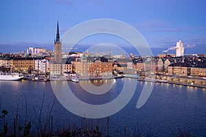 Beautiful panorama of Stockholm at night with sea, buildings, boats and night city lights.