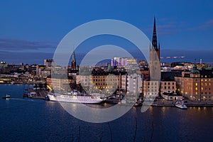 Beautiful panorama of Stockholm at night with sea, buildings, boats and night city lights.