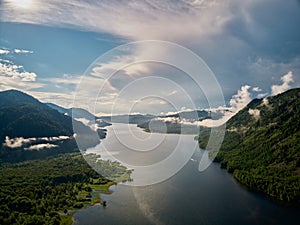 Beautiful panoramic landscape above clouds and mountains with sun rising in the middle.