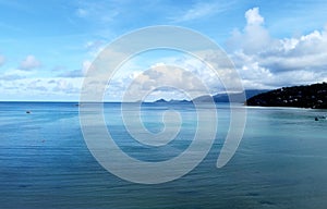 Beautiful panoramic landscape with clear blue ocean water and mountains on coast on Seychelles