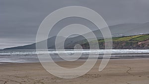 Beautiful panoramic landscape on Dingle Peninsula, Ireland. Panoramic dune landscape with mountain silhouettes and dark rain