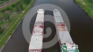 Beautiful panoramic landscape from high altitude two cargo commercial ships sail down the river on counter courses