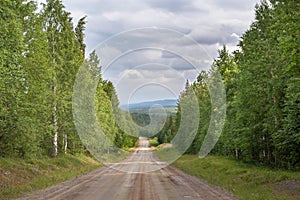 A beautiful panoramic macadam road through the forest in Finland.