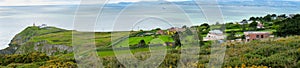 Beautiful panoramic scenery of Howth Head with Baily Lighthouse and green fields, county Dublin, Ireland