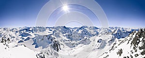Beautiful panoramic shot of snow covered mountain ranges under a clear blue sunny sky