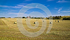 Beautiful panoramic view of afield with straw bales and a blue sky with clouds