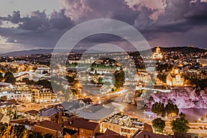 Beautiful panoramic view of evening Tbilisi, capital of Georgia. City colorful lights, river,cathedral,old buildings at a nice