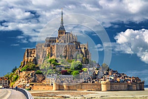 Beautiful panoramic view of famous Le Mont Saint-Michel tidal island with blue sky. Normandy, northern France