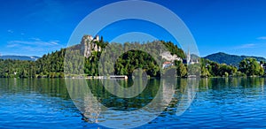 Beautiful panoramic view of the shore of Lake Bled with a medieval castle and the Catholic Church of St. Martin