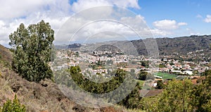 Beautiful panoramic view of Teror between hills covered by green vegetation on sunny day in Gran Canaria island, Spain