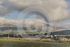 Beautiful panoramic view of a valley with small white houses and light poles with mountains