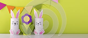 Beautiful paper flower with cute handmade bunnies on a green background