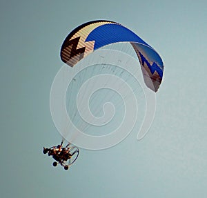 Beautiful paraglider on a background of blue sky. Paragliding. Hobb.