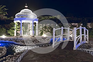 Beautiful park with gazebo and wooden bridge with night lighting. North Cyprus landscape