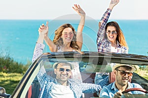 Beautiful party friend girls dancing in a car on the beach happy