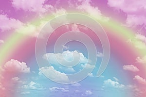 Beautiful pastel color with rainbow shade on white fluffy clouds, colorful blue sky on background, upward view and copy space