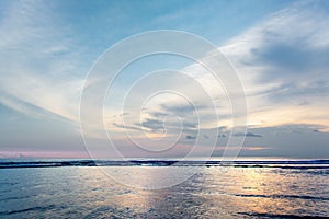 Beautiful Pastel Sunset or Sunrise at Beach with Sun Light Reflection on Sea Water Surface. Cirrus Lenticular and Altocumulus Clou