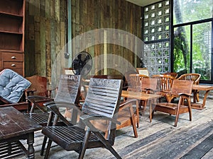 Beautiful patio seating area with wooden chairs, table and bench. Wooden classic furniture for leisure time on a covered patio.