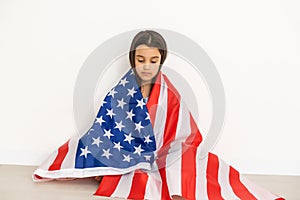 Beautiful patriotic little girl with the American flag held in her outstretched hands