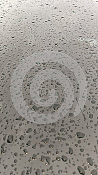 A beautiful pattern of raindrops sticking to the car windshield