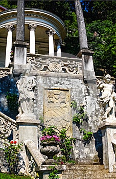 Beautiful pavilion with the ancient sculptures in the botanical garden of Villa Monastero, Varenna, Italy.