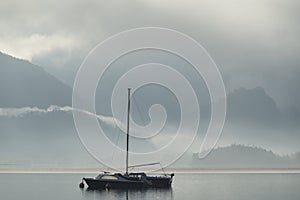 Beautiful peaceful image of sailing boat on Derwentwater in Lake District on a Winter morning