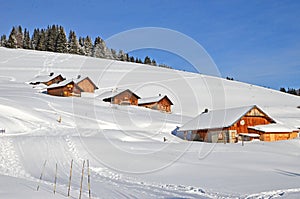 Beautiful peaceful winter landscape in the Frence Alps, at one of the ski stations, France. Several typical wooden houses