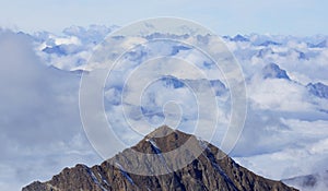 Beautiful peaks in the Alps surrounded by light white clouds photo