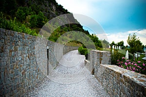 Beautiful pebble road along a stone fence