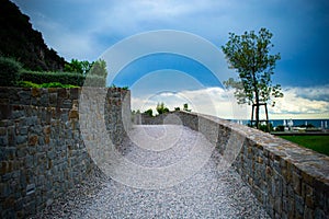 Beautiful pebble road along a stone fence