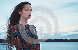 Beautiful pensive woman near the river