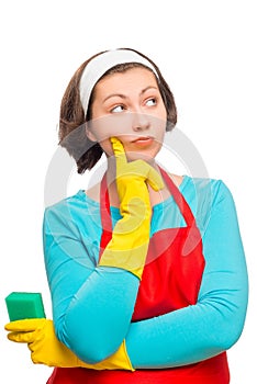 Beautiful pensive woman with a sponge thinks that to clean